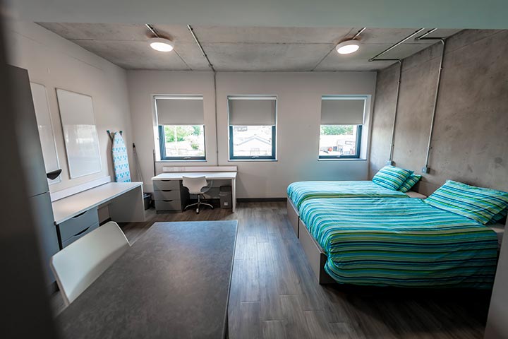 Two double beds in a room with 2 desks
