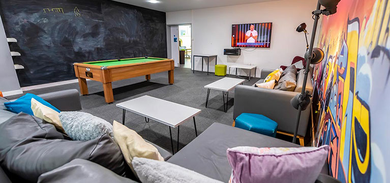 Pool table, sofa's and a chalk board wall