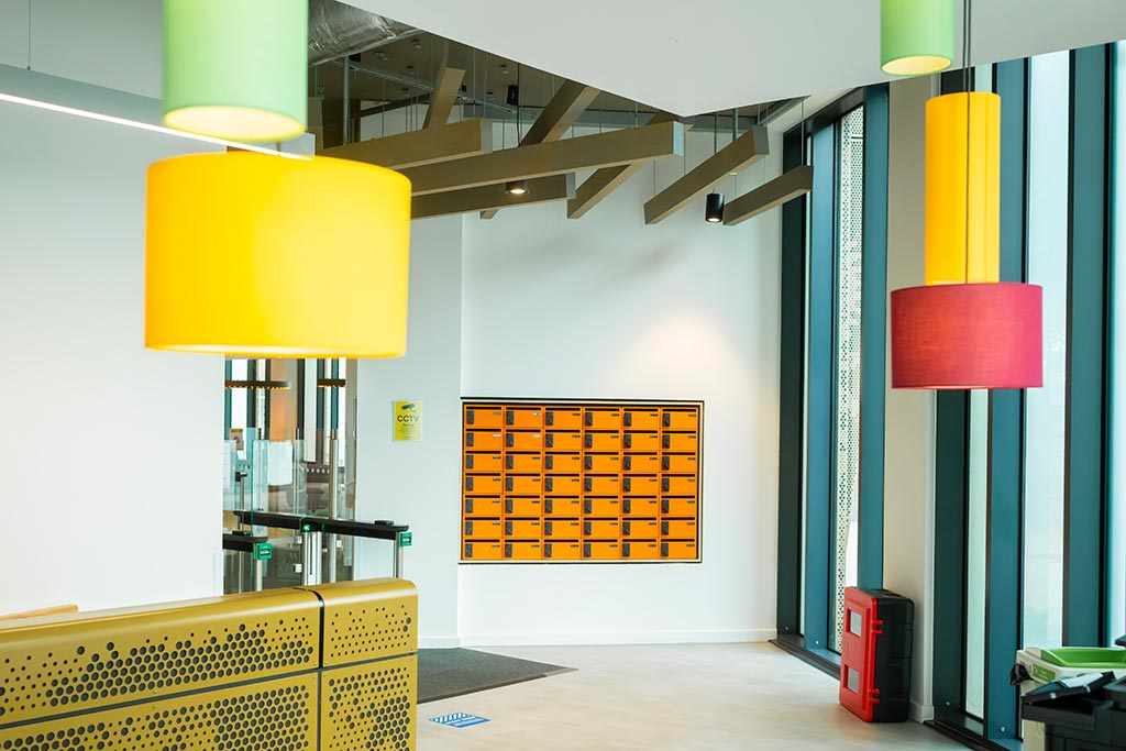 Reception area of Godiva Place with wall mounted lockers and colourful lamp shades