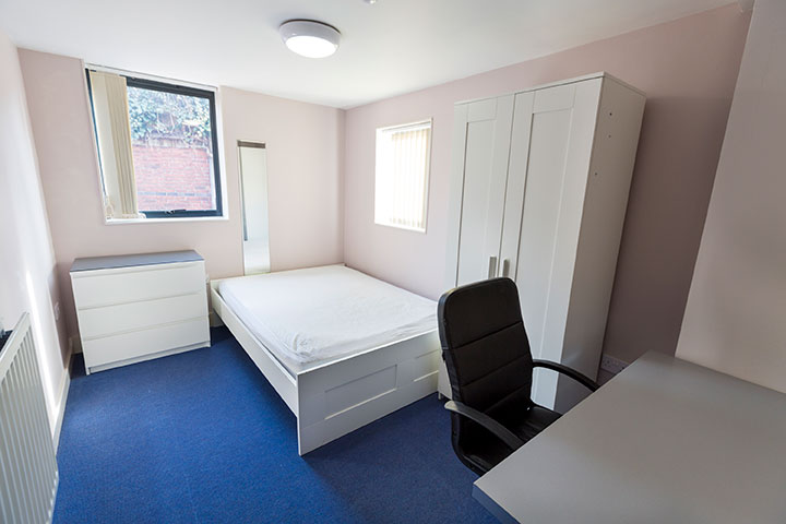 Double bed, wardrobe, drawers and desk in a standard room