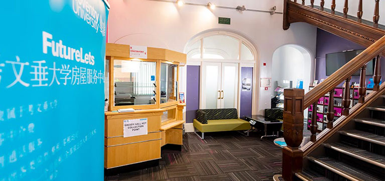 Reception area with a desk and stairs going up to the first floor.