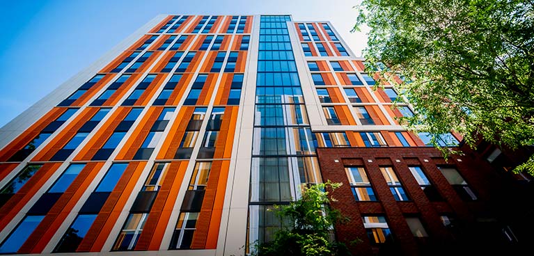 Bishop Gate student accommodation with orange cladding pictured on a sunny day