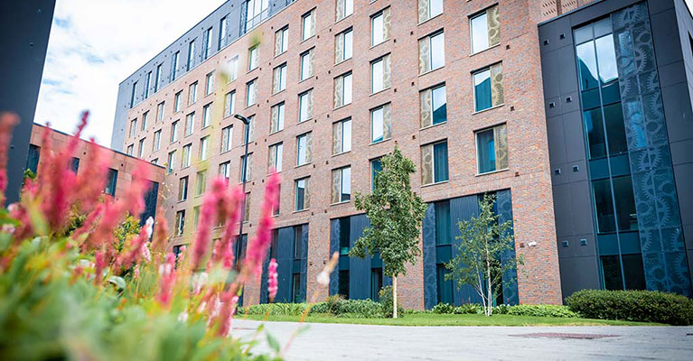 Exterior view of Godiva Place with pink flowers