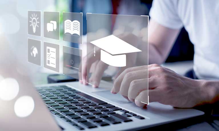 Hands typing at a keyboard with a projection of a graduation hat