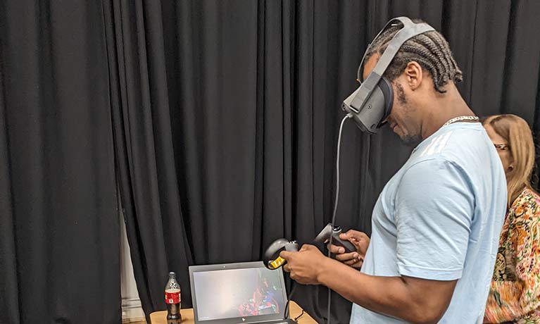 student wearing a VR set looking down at a console