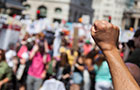 Close up of raised fist against blurred background of a crowd