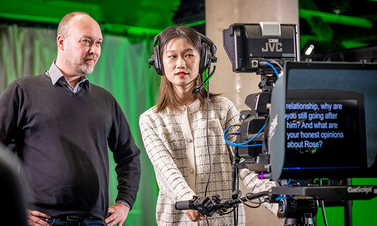 Student operating a teleprompter in a tv studio