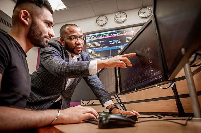 Lecturer and student working in the trading floor