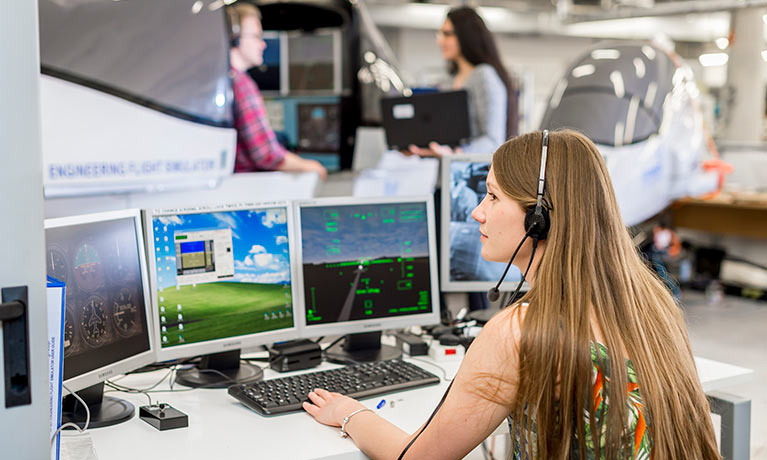 Student looking at monitors analysing flight navigation