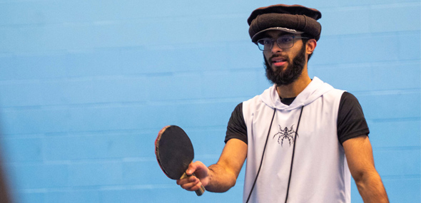 A student playing table tennis with a friend
