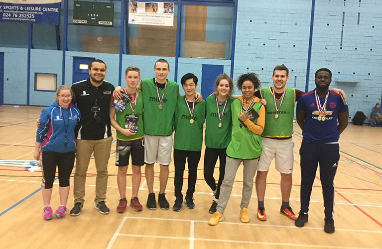 team photo of nine players inside a sports centre