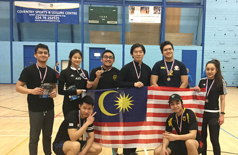 Team photo of eight players in a sports centre