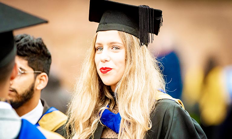 Young student wearing a graduation hat smirking