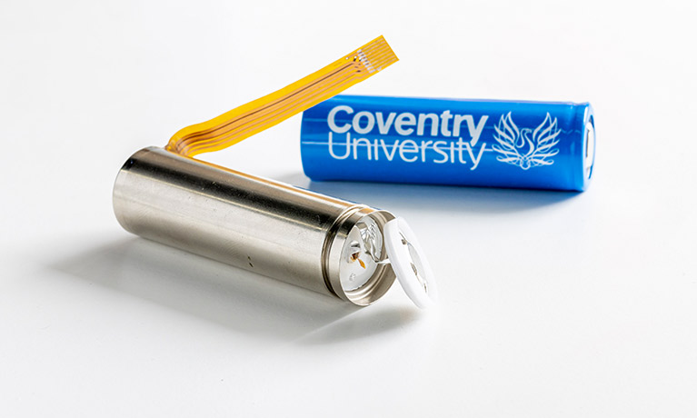 A battery with the Coventry University logo on it alongside a new type of battery with parts exposed