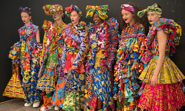 a line of women wearing Hayleigh Boadi's colourful dresses