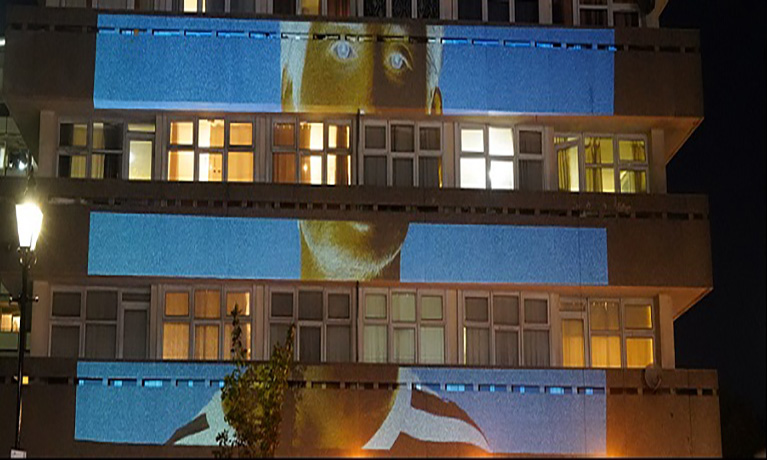 High rise building with an image of a person projected onto the building