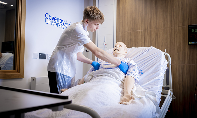 student attending to dummy patient