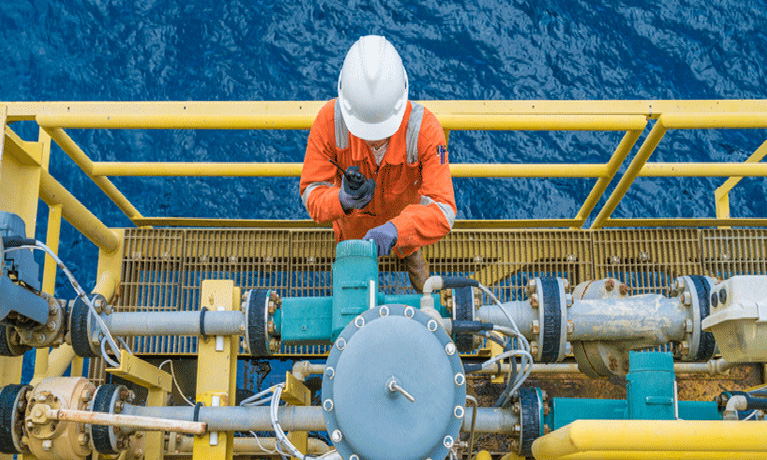 Man with hard hat on scaffold handling machinery