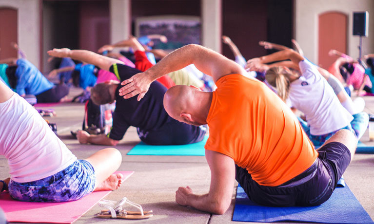 Group of people doing yoga exercises on a mat