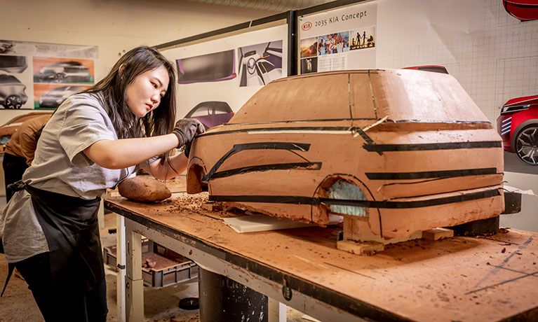Young lady working on a wooden model car