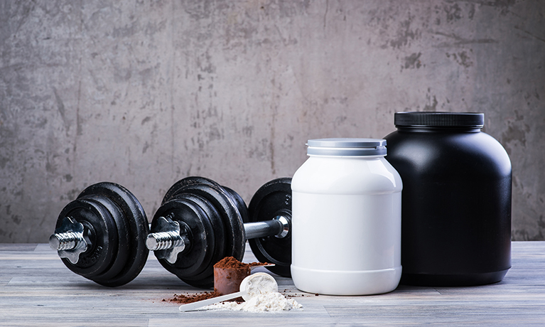 A mirror with protein powders in the foreground