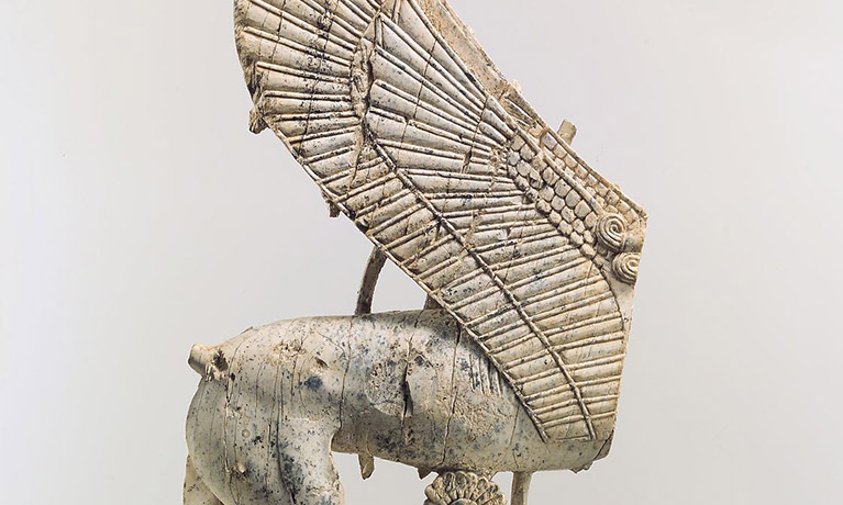 A broken wooden statuette of a sphinx