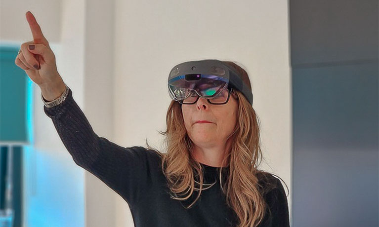 A woman wearing a virtual reality headset points