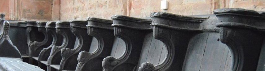 A row of empty old blackened pews.