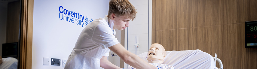 student attending to a dummy paitent