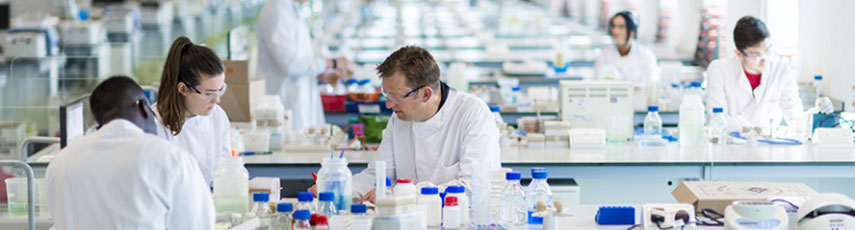 Researchers in white lab coats conducting experiments