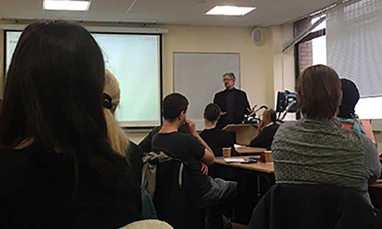 Man delivering briefing to room of people