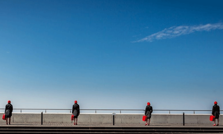 Ladies standing in front of barrier blue sky