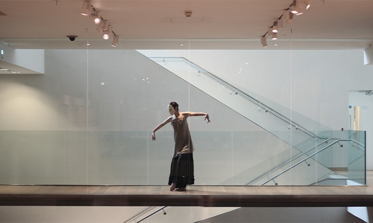 Person dancing in an empty room with a mask on