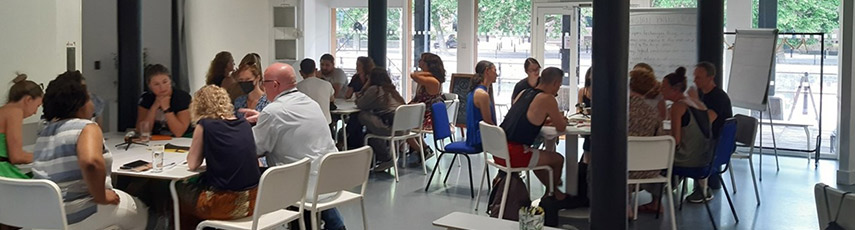 A room of people of sitting at tables talking.