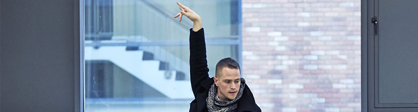 a man raises his arm in the air to dance Flamenco