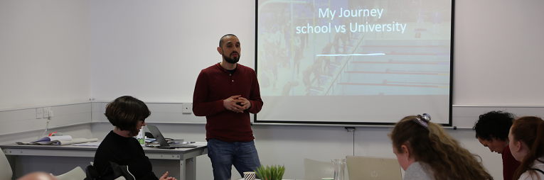 Lecturer addressing small class of students.