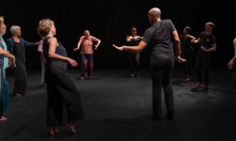 Dance researchers dancing in a circle in the dark
