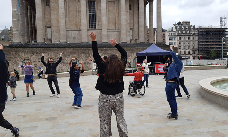 A group of people dancing in a city space