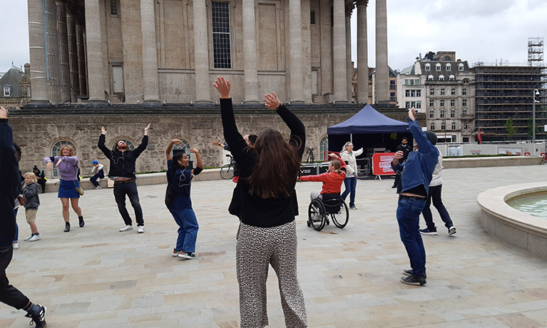 A group of people dancing in a city space
