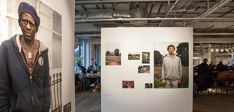 A photograph of a photography exhibition, featuring photographs of homeless men. 