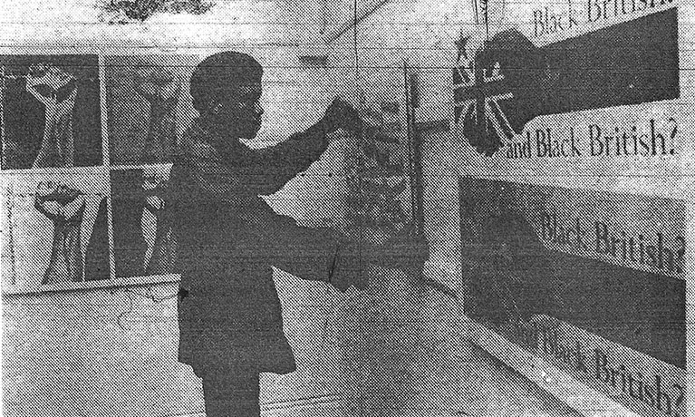 An old newspaper clipping of a man pinning art onto a wall