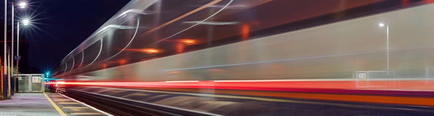 Train passing through a station at high speed captured as motion blur