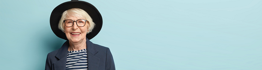 Woman with white short hair wearing a big black hat