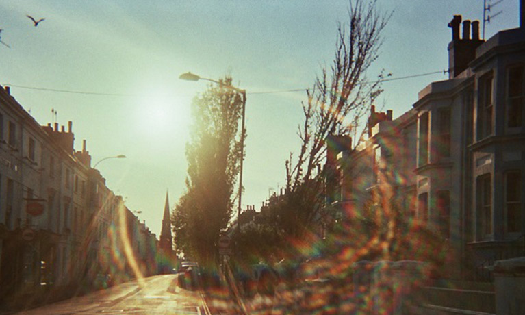 a photograph of a street with a lens flare