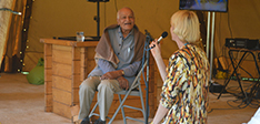 Satish Kumar sat on a chair with a person asking a question with a microphone
