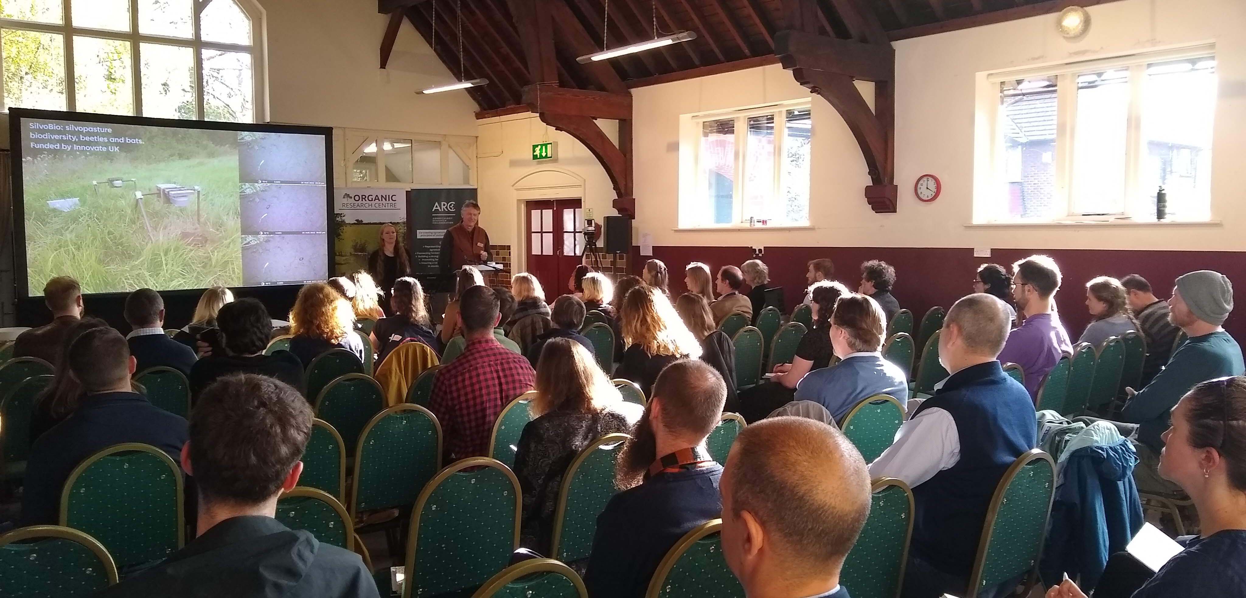 Group of people sat in a hall watching a presentation