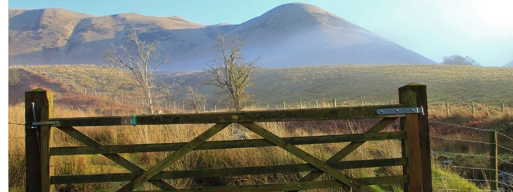 Gate in countryside with mountain backdrop 