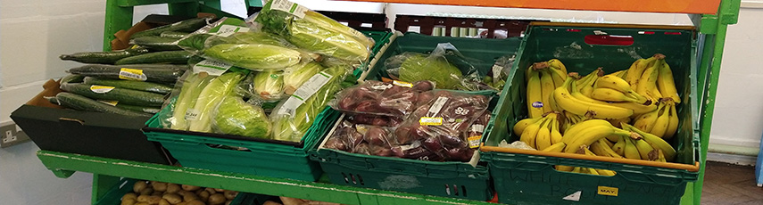 Crate filled with cucumbers and bananas.