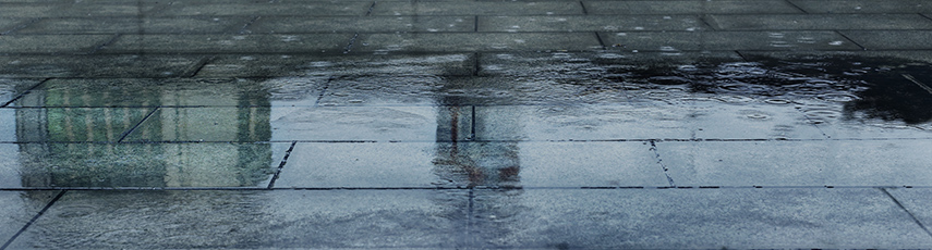 Puddle of water on a pavement on a rainy day