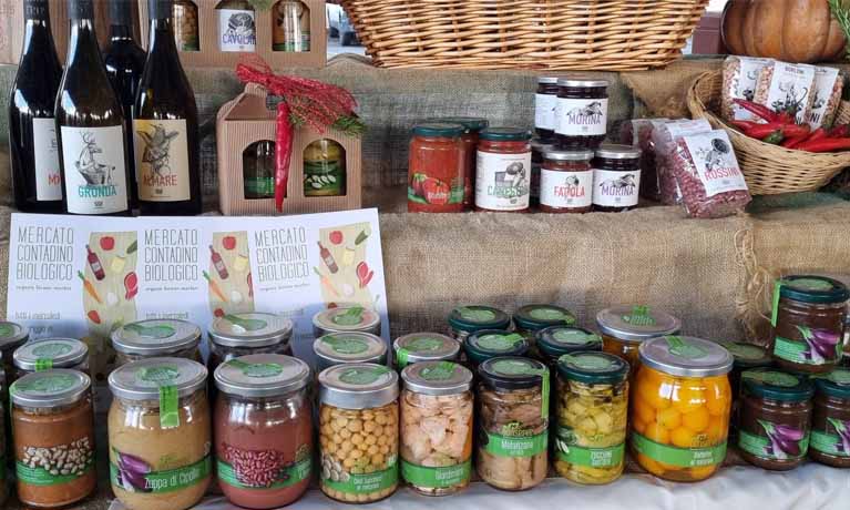 Various jars, packets and bottles of food displayed in outdoor market display setting